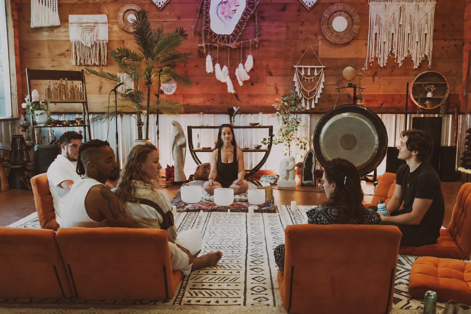 A warm ceremonial sound-bath gathering in an intimate wood-lined studio